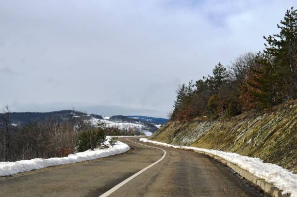 istock mountain road in winter in the snow 1303544391