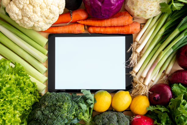 istock Isolated tablet screen among healthy food vegetables. tablet for writing diet notes. 1303545558