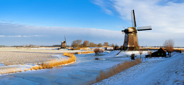 Windmills in winter setting during sunrise. The location is Schermerhorn, Netherlands
