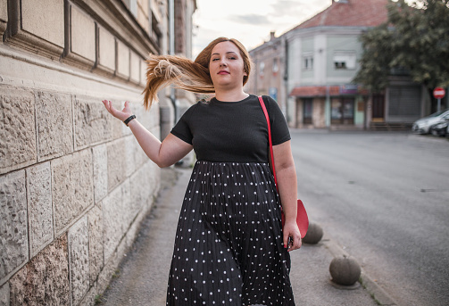 Beautiful blonde confident plus size model woman walking in the city