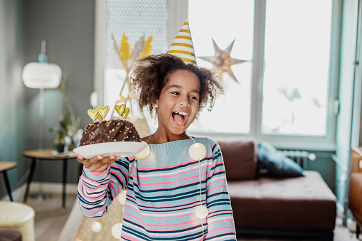 Portrait of African American girl holding a birthday cake