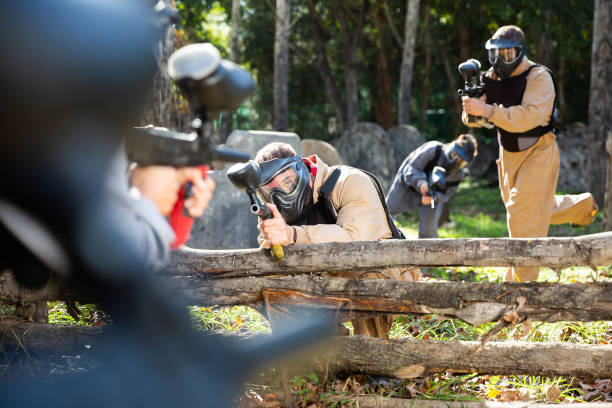 istock Paintball players shooting with guns 1303553582