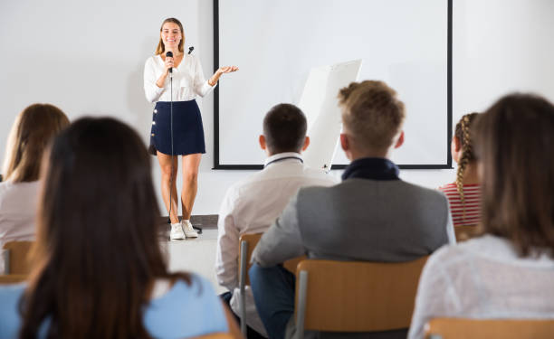 istock Female teacher lecturing to students 1303554817