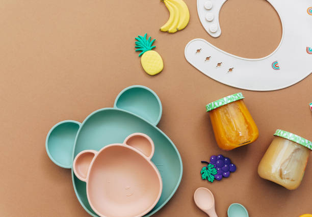istock Bright silicone dishware on light background. Serving baby, first feeding concept. Flat lay, copy space, top view 1303555790