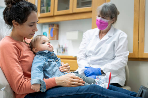 istock Mother holding daughter during pediatric dental appointment 1303556729
