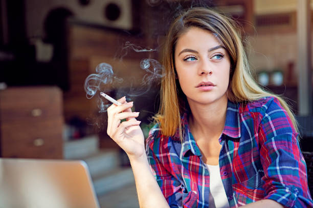 istock Depressed young woman is smoking in a cafe 1303557326