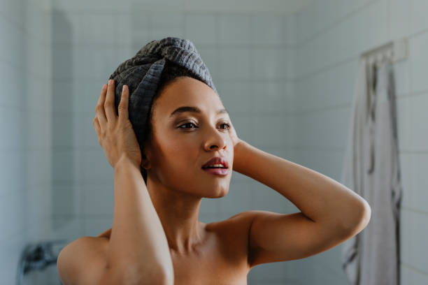 Portrait of a Beautiful Afro Woman who's just Washed her Hair A portrait of a young woman after washing her hair, with a towel wrapped over her head. towel stock pictures, royalty-free photos & images