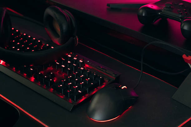 istock Gamer work space concept, gaming gear, mouse, keyboard, joystick, headset, headphone and mouse pad on black table background. 1303559304