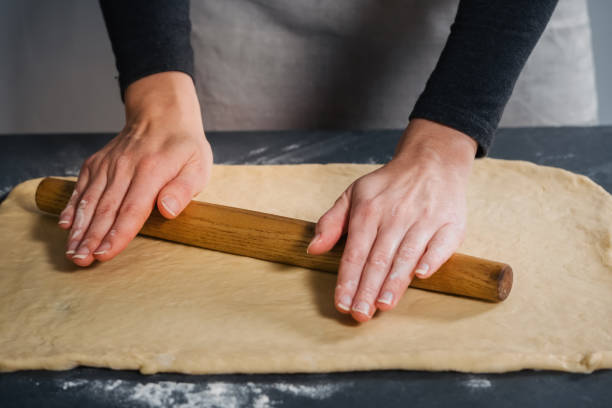 istock Woman rolling out the dough for buns 1303560509