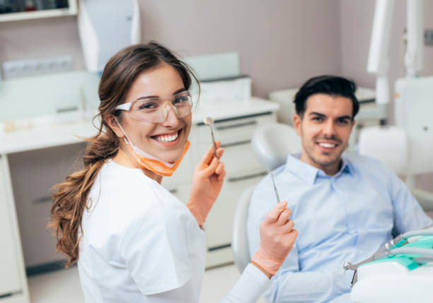 At the Dentist Portrait of young female dentist looking at camera and smiling while working dental hygienist stock pictures, royalty-free photos & images