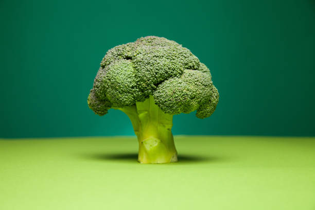istock Green nutrient broccoli against two color background 1303561475