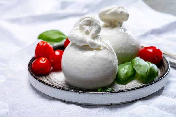 coleção de queijo, bola de queijo burrata branca fresca feita de mussarela e creme de apulia, itália - buratta - fotografias e filmes do acervo