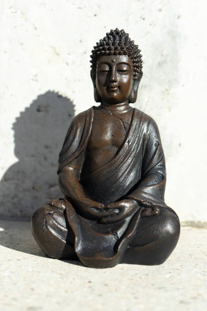 istock Buddha statue near house in front of wall. 1303563582