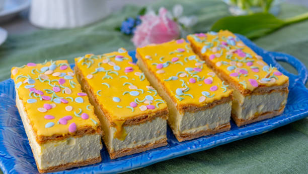 torte di tompouce con panna montata e glassa gialla servite nel soleggiato giardino primaverile - tompouce foto e immagini stock