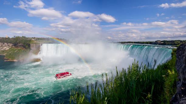 nave da crociera turistica sotto rainbow sul fiume niagara che visita le cascate d'acqua in un soleggiato tour in barca del giorno d'estate hornblower and maid of the mist per un turista appassionato da vicino - hydro power foto e immagini stock