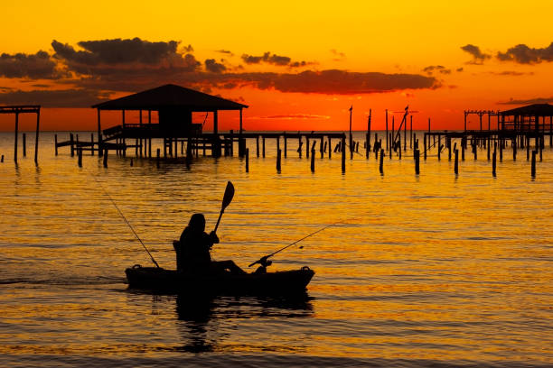 A kayaker takes in the sunset as dusk settles over Mobile Bay as seen from Fairhope, Alabama, USA, on Nov. 22, 2020.