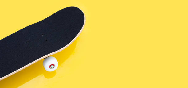 istock Black skateboard on yellow background. 1303571458