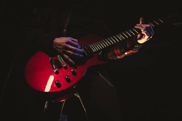 istock Guitarist playing red electric guitar 1303573134