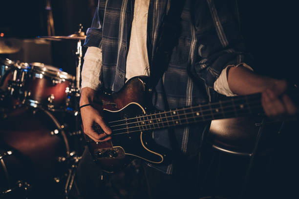 istock Guitarist playing red bass guitar 1303573143