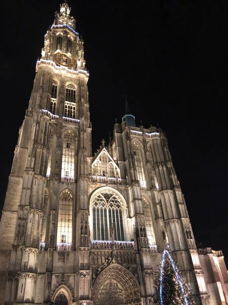 istock Church in Antwerp at night with Christmas tree 1303573929