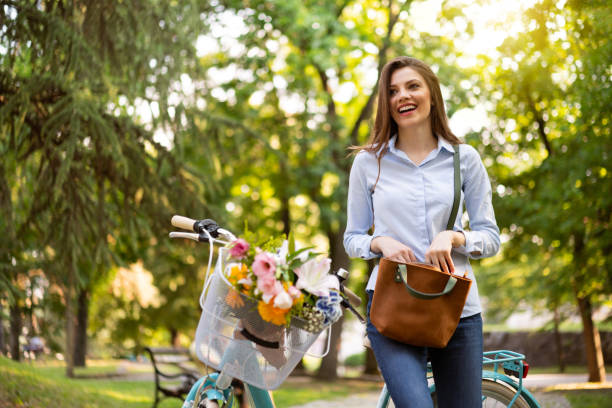 istock Smiling young woman on bicycle 1303581744