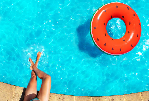 istock Woman's legs, inflatable watermelon swim in pool 1303581876