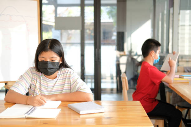 istock girl student wearing face mask  studying writing notes doing homework. learning education at school 1303582086
