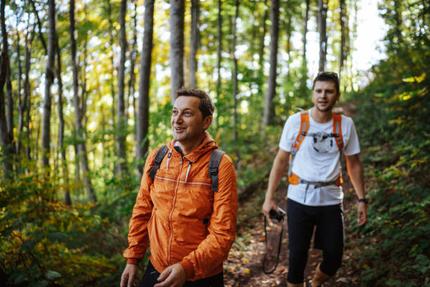 istock Happy male hikers in autumn forest 1303583868