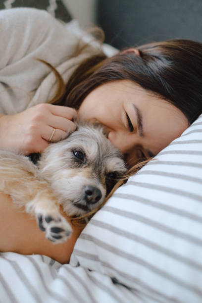 istock Woman cuddles dog in bed 1303587558