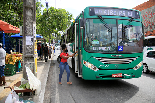 salvador, bahia, brazil - february 19, 2021: person taking public bus in the city of Salvador. Because of the curfew decree, collectives will change in circulation times.