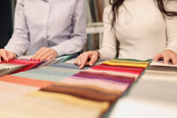 istock Designer and client choosing fabric in catalog closeup 1303589872