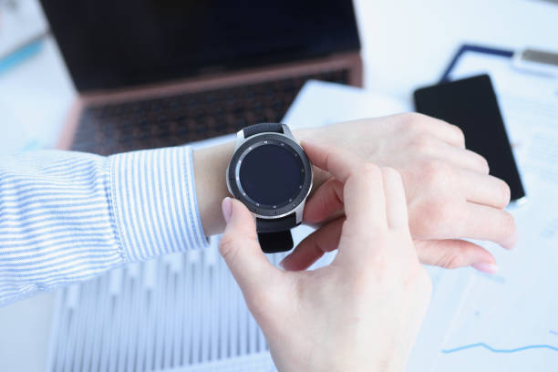 istock Woman looking at smart watch at workplace closeup 1303589883
