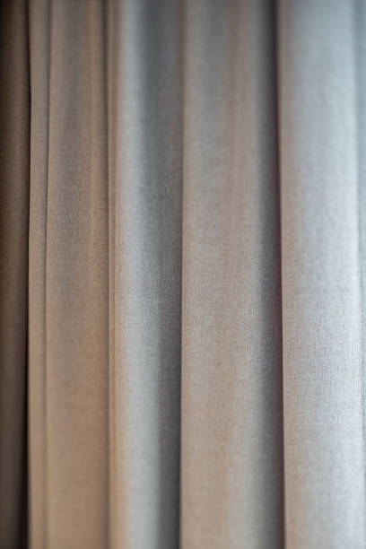 istock Close-up of grey curtains. Fabric texture. Modern interior. 1303590220