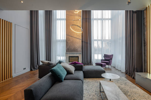 istock Interior of luxury apartment. Huge cozy sofa. Fireplace. 1303590224