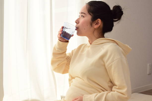 istock pregnant woman drinks water 1303590872