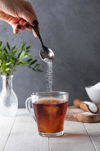 En una taza de té, vierta un sustituto de azúcar de una cucharadita. Stevia, eritritol. photo