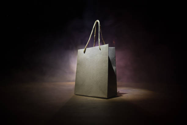 istock Brown shopping bag with handles placed on dark desktop. Shopping concept 1303593627