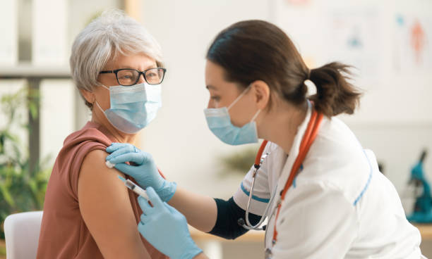istock Doctor vaccinating a senior woman 1303595152