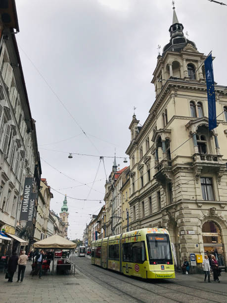 azjata pozuje z tramwajem cityrunner w grazu, austria. - cityrunner zdjęcia i obrazy z banku zdjęć