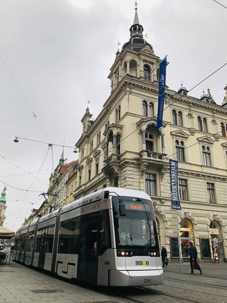 azjata pozuje z tramwajem cityrunner w grazu, austria. - cityrunner zdjęcia i obrazy z banku zdjęć