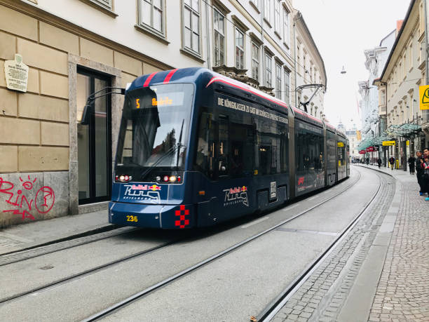 azjata pozuje z tramwajem cityrunner w grazu, austria. - cityrunner zdjęcia i obrazy z banku zdjęć