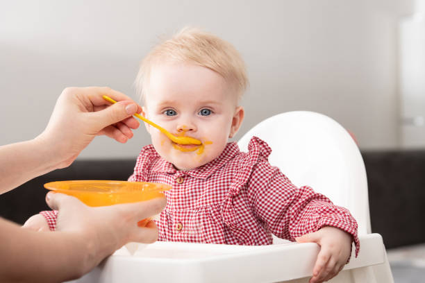 istock Mother Feeding Baby With Spoon 1303598502