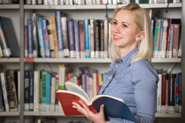 istock Happy Blonde Woman Working in the Library 1303599498