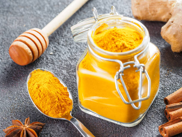 istock turmeric powder in glass jar and spoon 1303603522