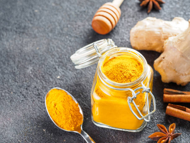 istock turmeric powder in glass jar and spoon 1303603524