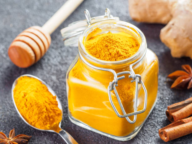 istock turmeric powder in glass jar and spoon 1303603559