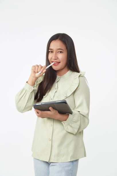 istock Wireless technology. Beautiful young woman holding digital tablet and looking at camera with smile while standing 1303604418