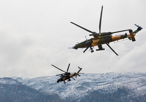 Attack helicopters flying over mountains