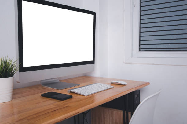 Computer monitor with white blank screen on the business desk with wireless mouse, keyboard at home office over white wall background, Photo of equipment contemporary workspace