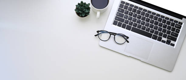 istock Horizontal photo of computer laptop, glasses, coffee cup and copy space on white background. 1303613779